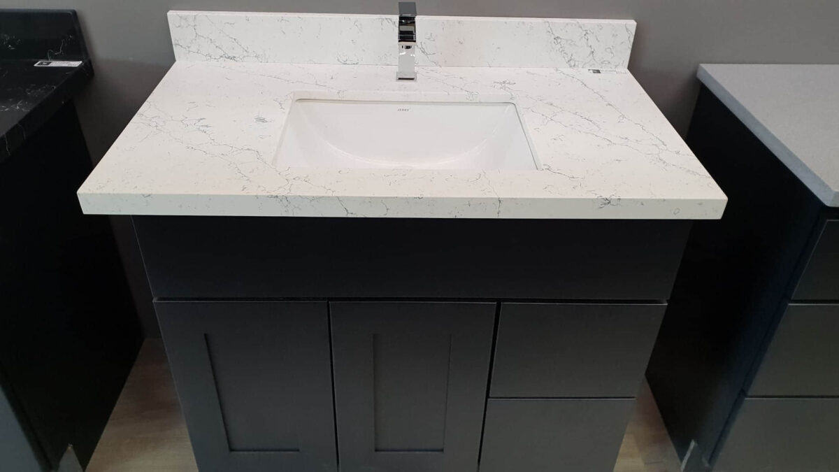 Modern bathroom vanity with white marble countertop and sleek black cabinet.