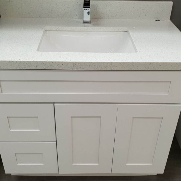 White bathroom vanity with sink and faucet.