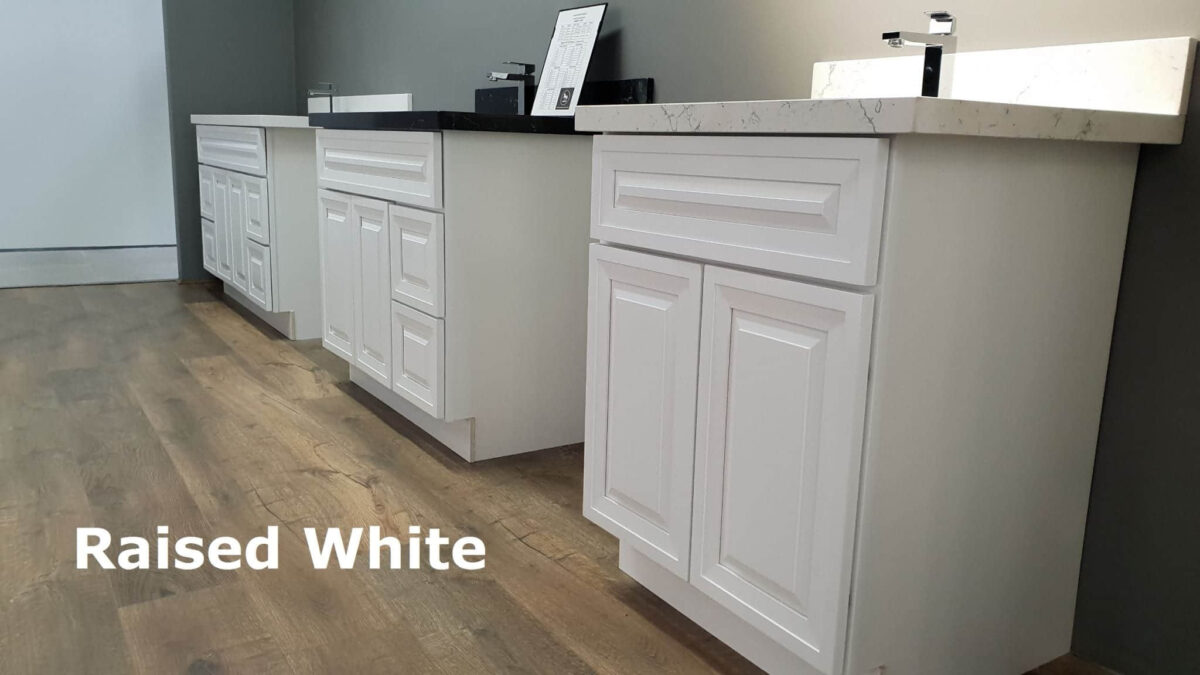 White kitchen cabinets with marble countertops and wood flooring.