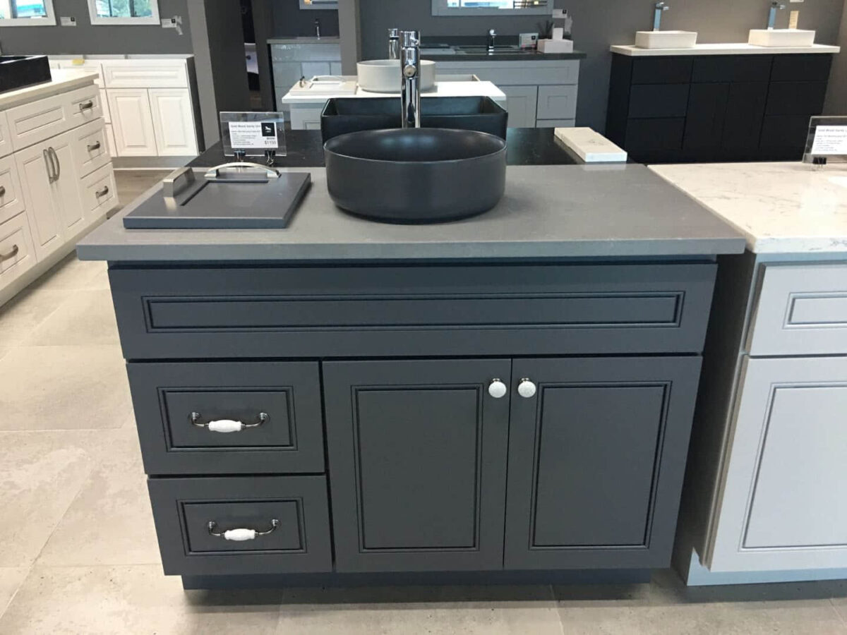 Dark gray kitchen cabinet with black sink and modern faucet.
