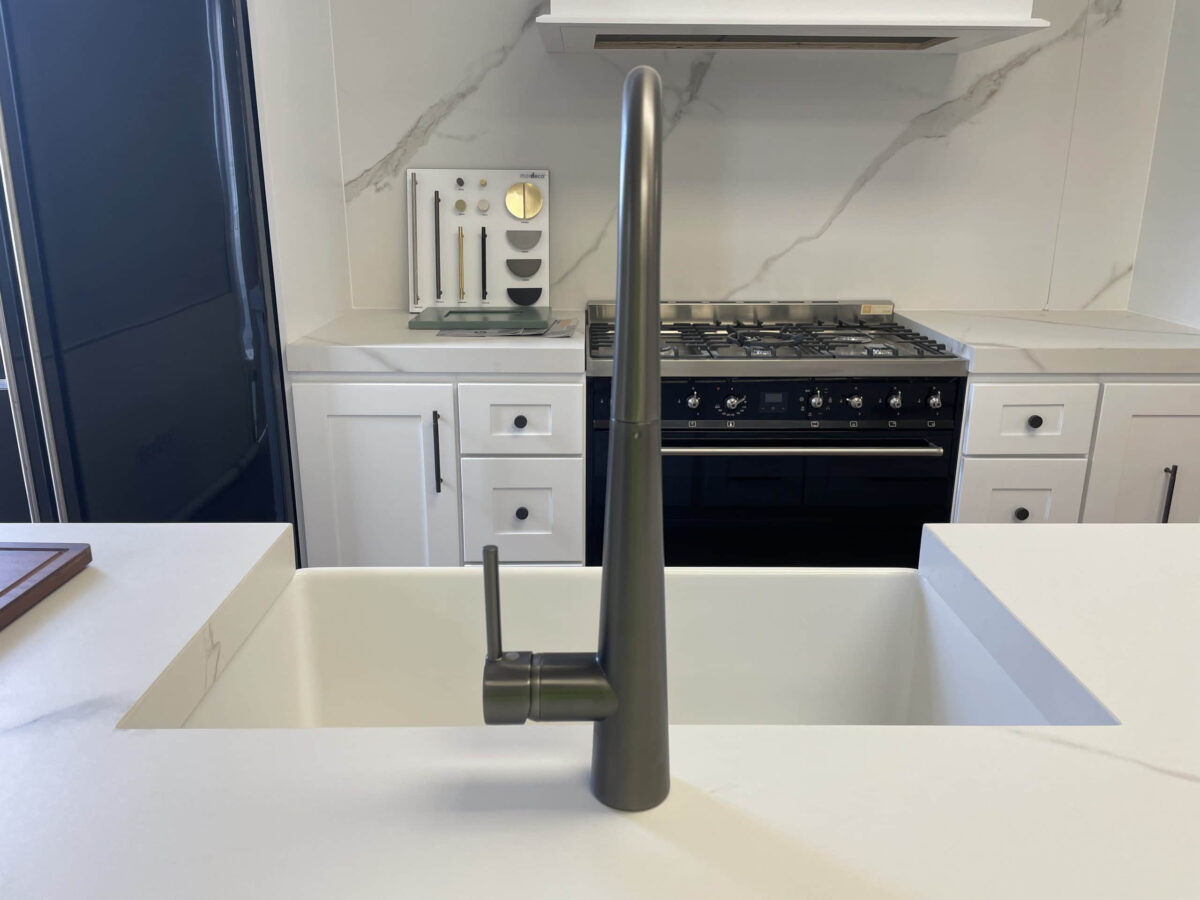 Modern kitchen with sleek faucet and marble backsplash.