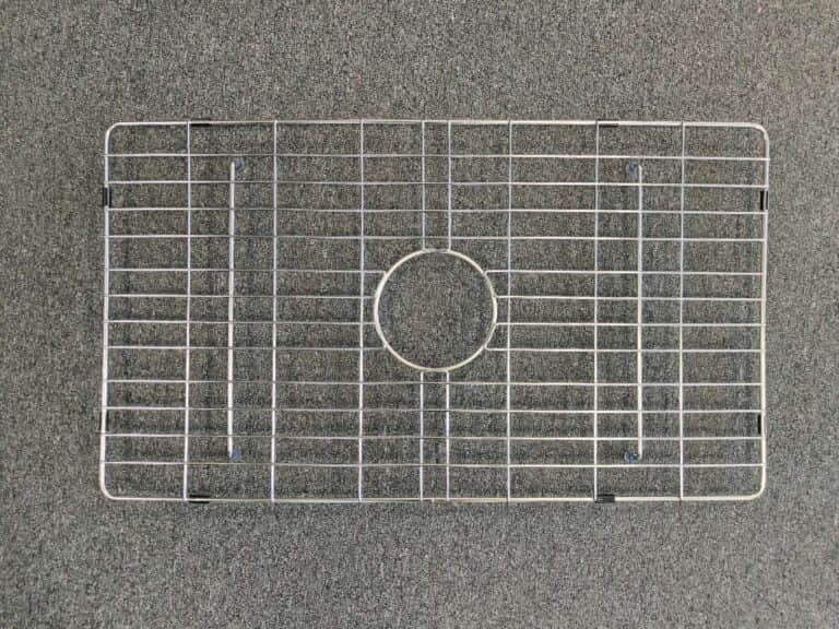Metal sink protector on a gray surface.