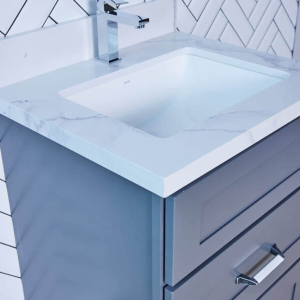 Modern bathroom vanity with marble countertop and herringbone tile backsplash.