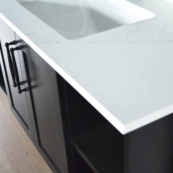 Modern kitchen countertop with white surface and dark cabinets.