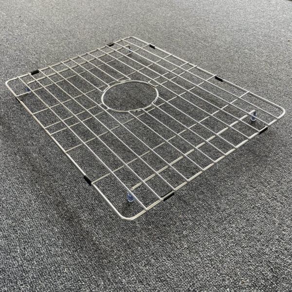 Stainless steel sink grid on gray carpet.