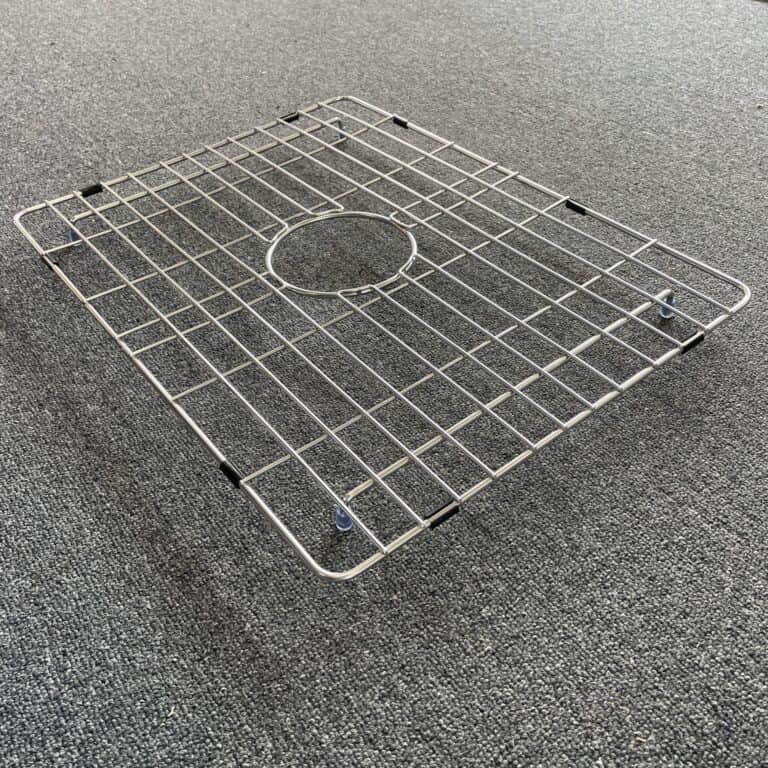 Stainless steel sink grid on gray carpet.