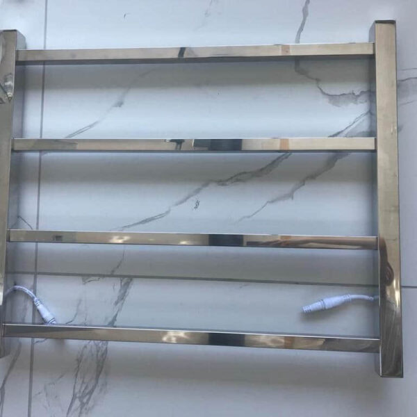 Silver square heated towel rail with four bars on tiled floor.