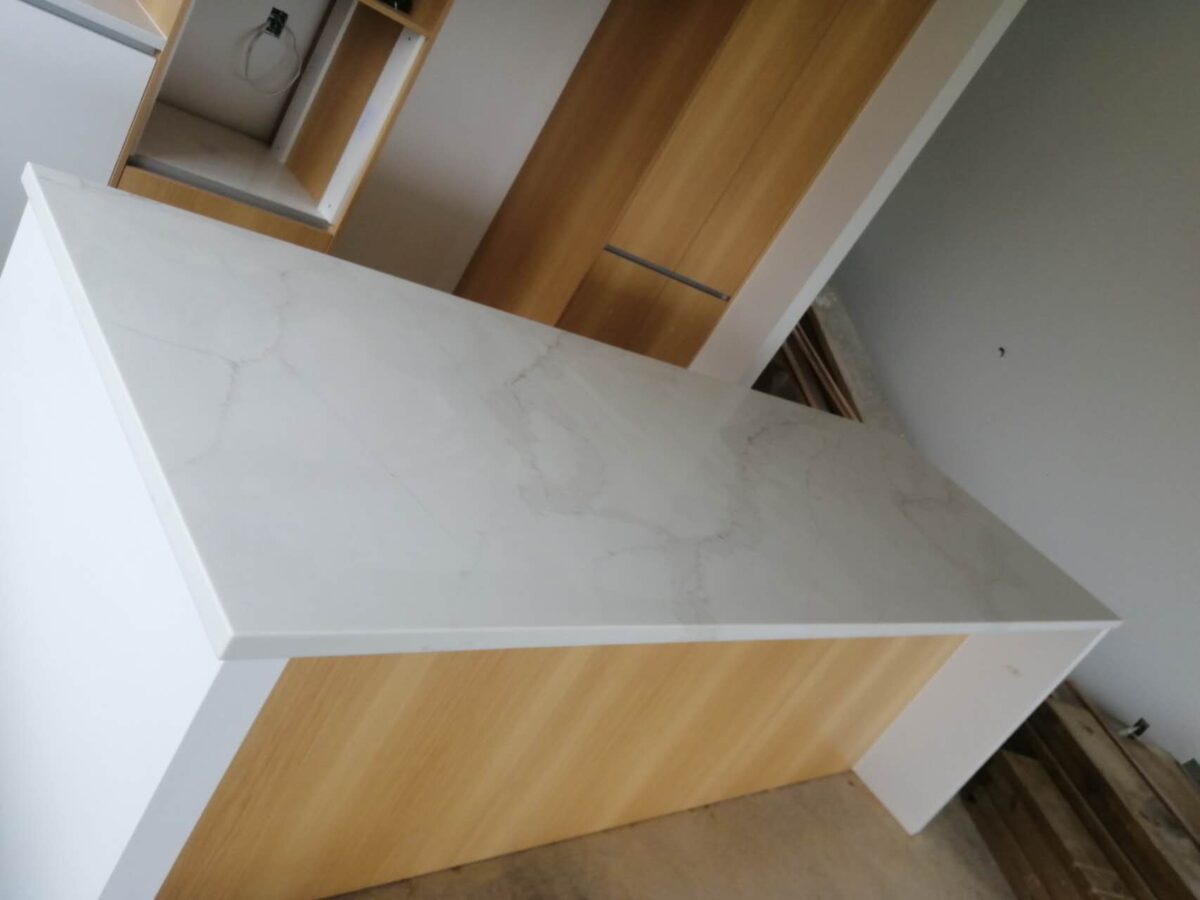 Marble kitchen countertop with wooden cabinets.