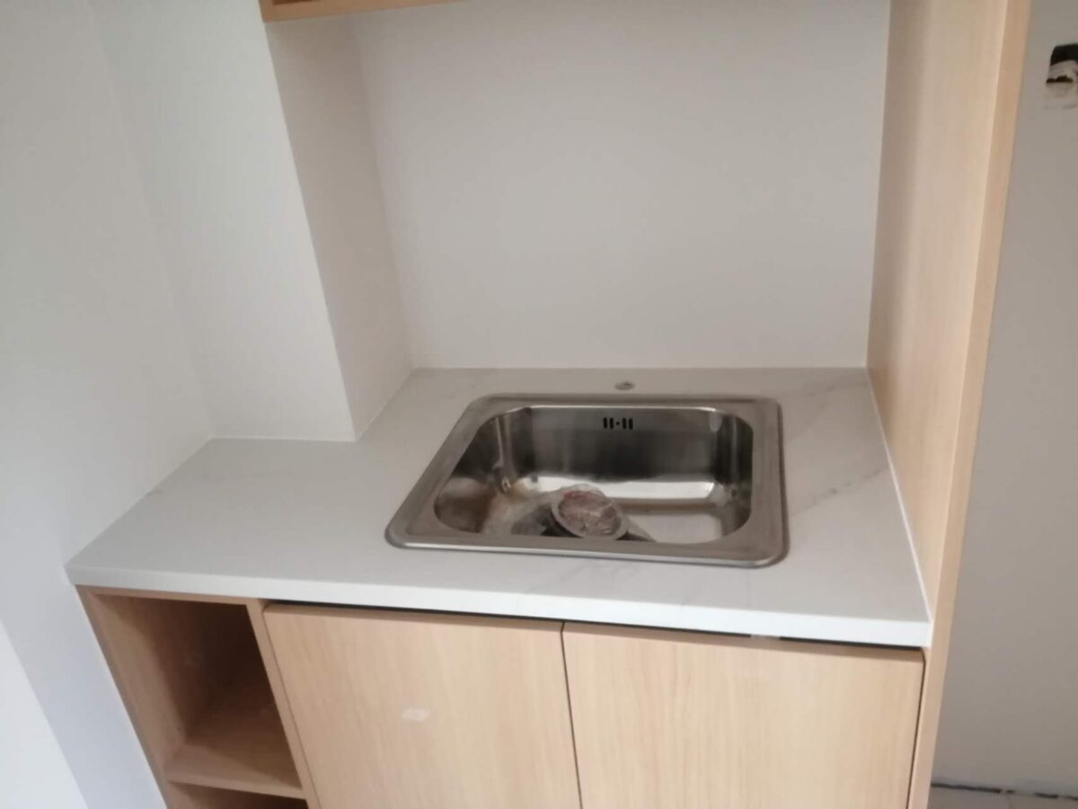 Modern kitchen sink with Calacatta Belleza countertop and wooden cabinets.