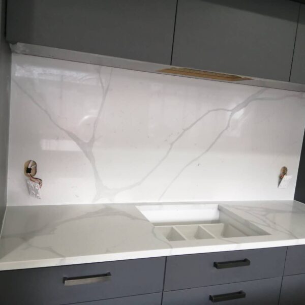 Calacatta Sky Quartz countertop and backsplash in modern kitchen setting.
