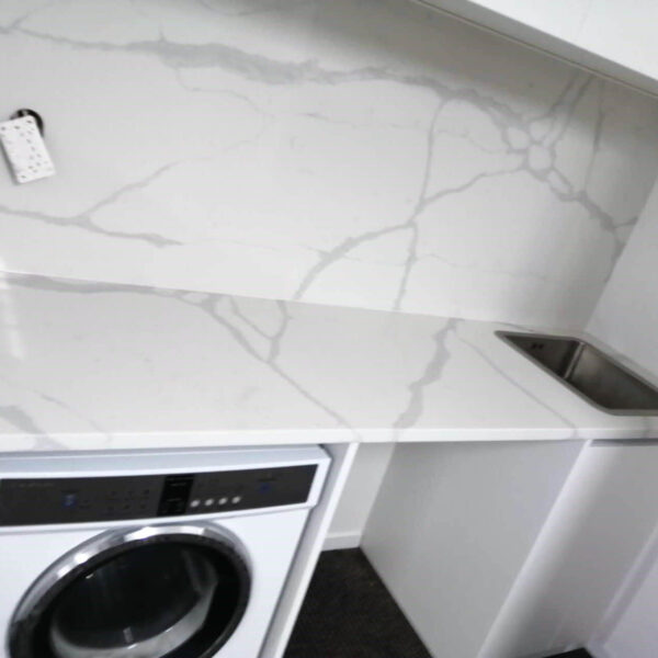 Laundry room with Calacatta Sky Quartz countertop and backsplash.