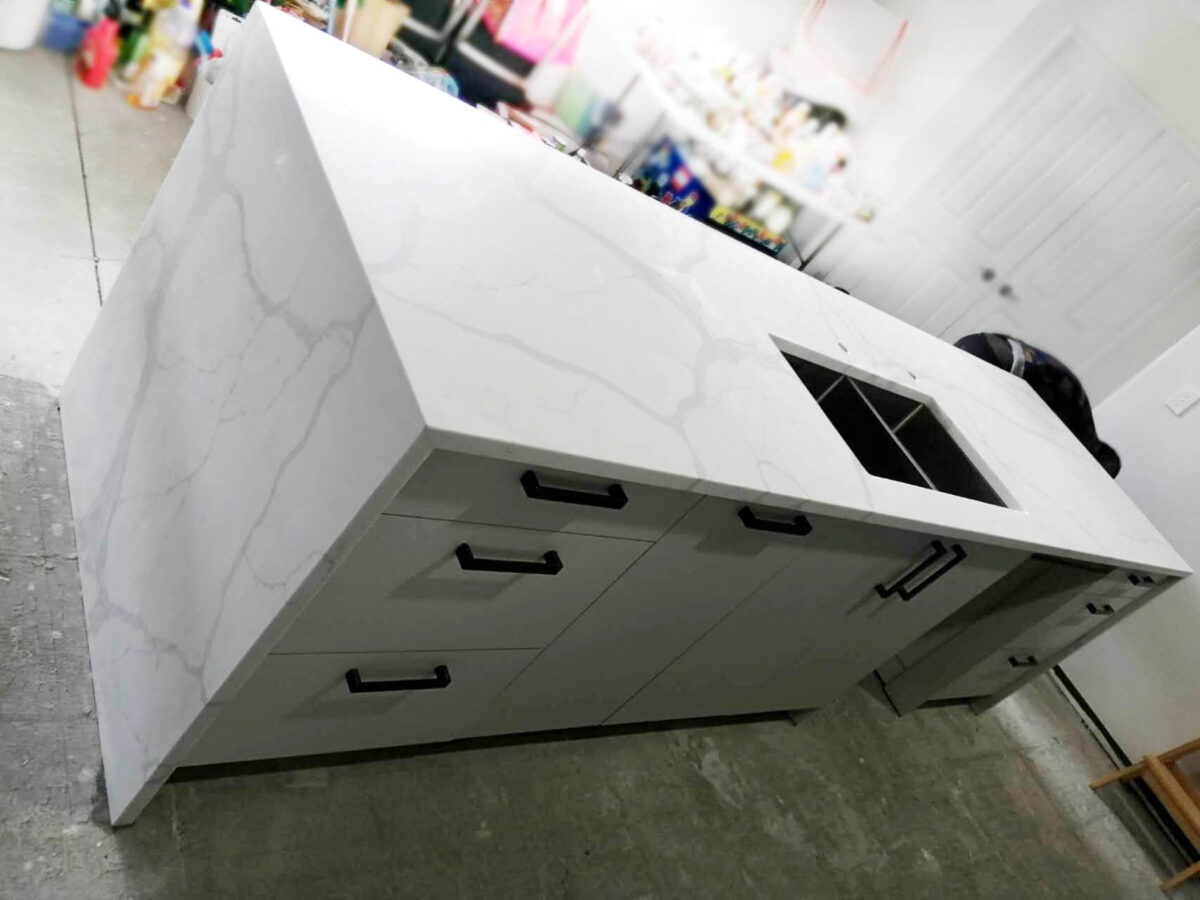Calacatta Sky Quartz kitchen island with sink and drawers.