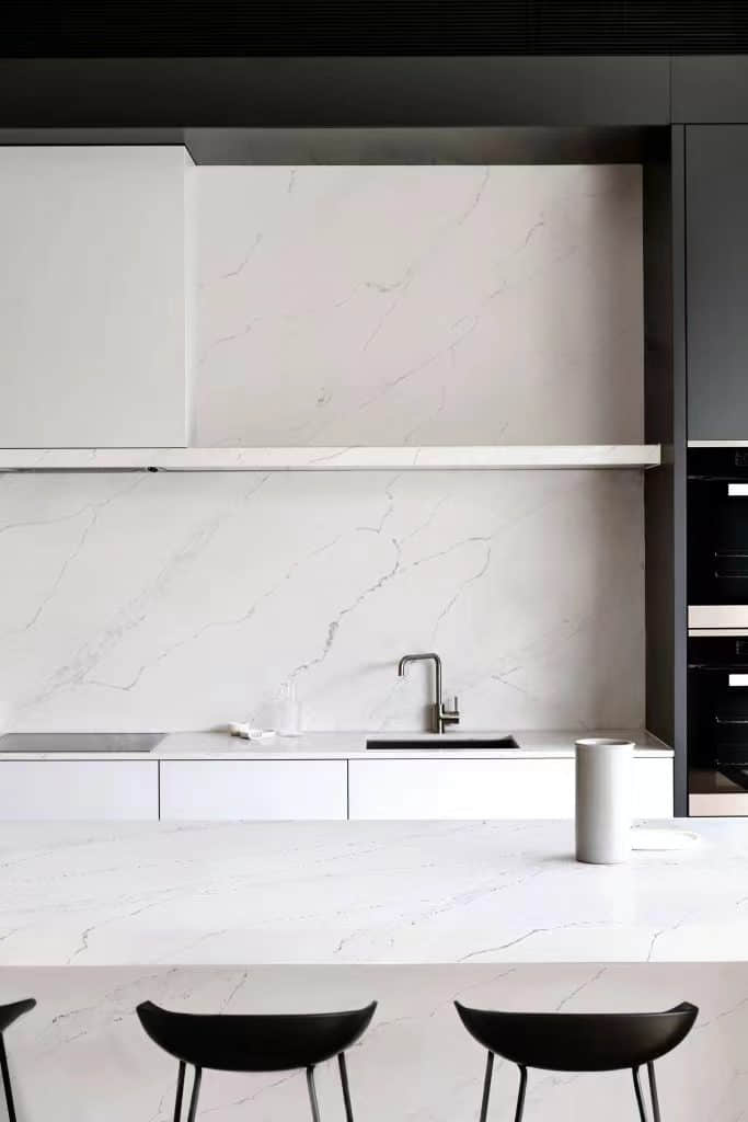 Modern kitchen with marble countertops and minimalist design.