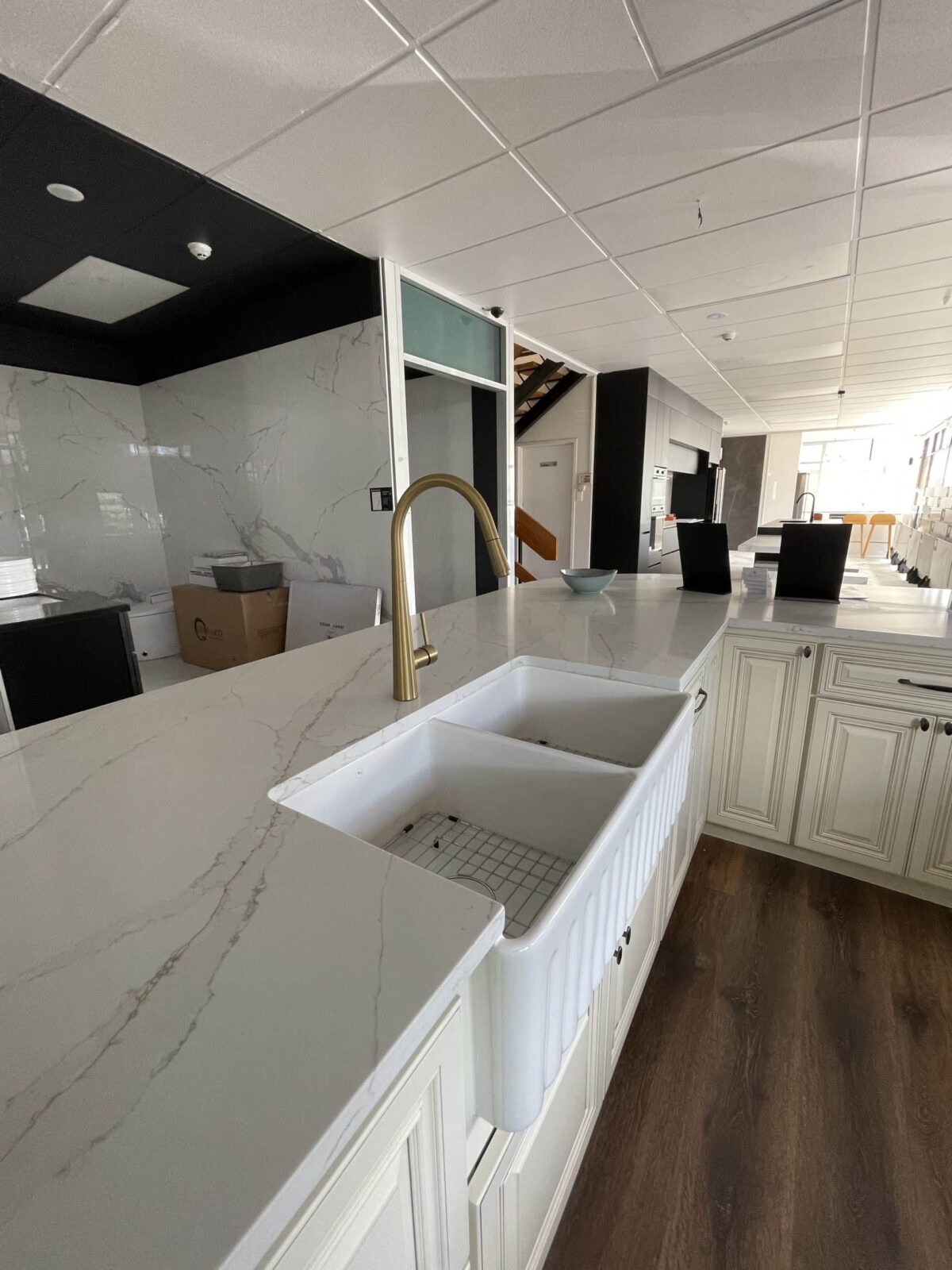 Modern kitchen with marble countertops and farmhouse sink.